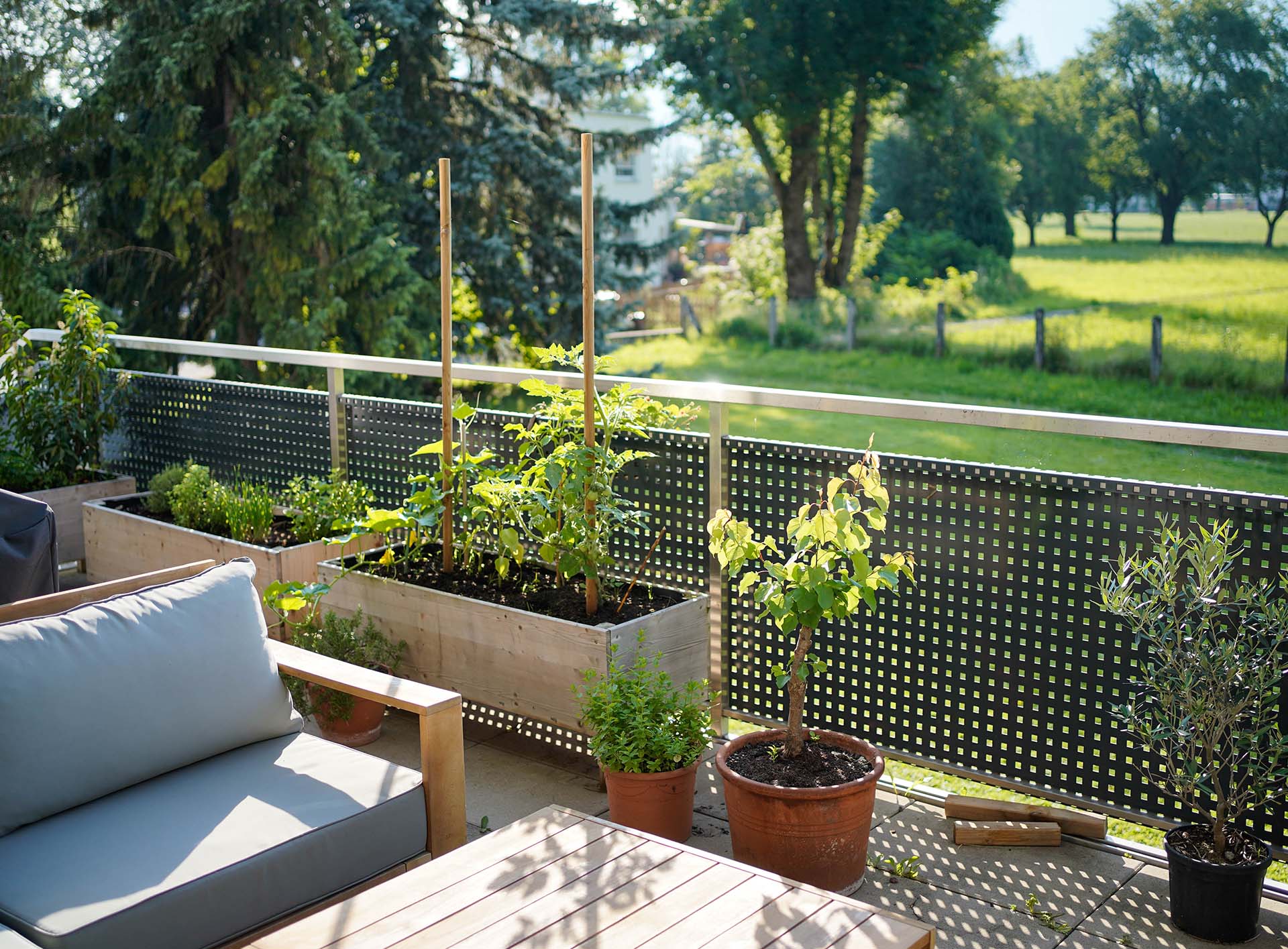 Sicht auf Terrasse mit bepflanztem Hochbeet 