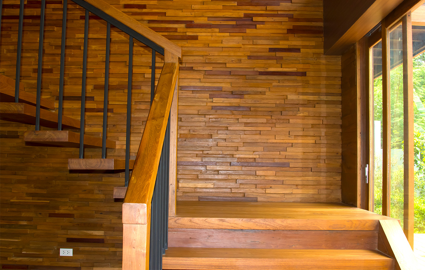 Eine moderne Holztreppe mit eleganten Wandpaneelen aus Holz, die den Bereich harmonisch und stilvoll gestalten.