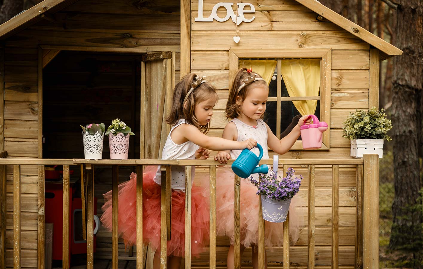 zwei Mädchen spielen im Kinderspielhaus aus Holz